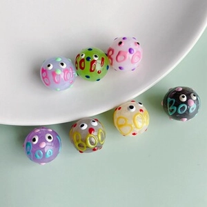Close-up of Halloween colorful glass cube beads with eye patterns and BOO text