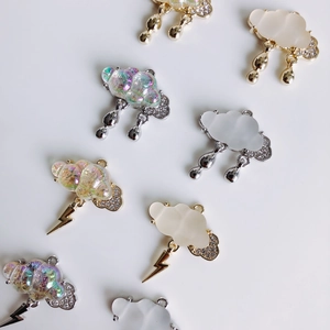Dettaglio di ciondoli a forma di nuvola con saette in placcatura oro e argento per DIY
