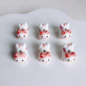 Dettaglio di perline in ceramica a forma di gatto per gioielli fai da te