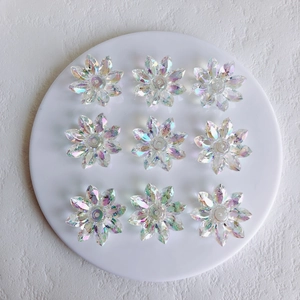 Detailed view of nine iridescent acrylic flower charms for DIY jewelry making
