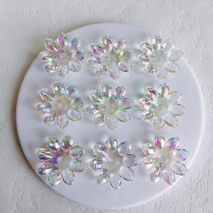 Close-up of nine transparent Aurora AB acrylic flower pendants for DIY jewelry making