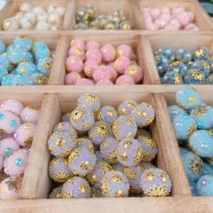 Ethnic style DIY macaron beads with golden filigree caps in a wooden storage box