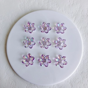 Macro shot of nine translucent iridescent purple acrylic flower beads for DIY jewelry making