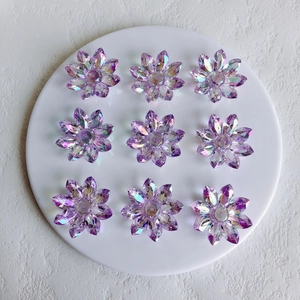 Macro detail of nine purple aurora acrylic flower pendants for DIY jewelry making