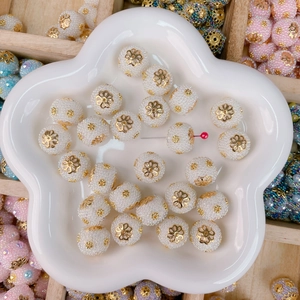 Macro view of white textured beads with gold metal flower caps for DIY jewelry crafting