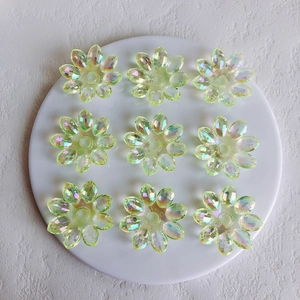 Detail view of iridescent acrylic flower charms for jewelry making in aurora yellow green