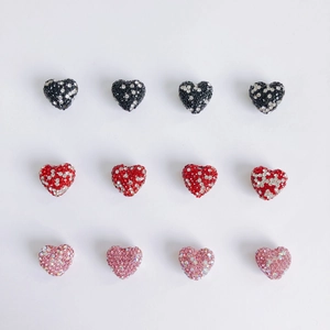 Macro view of heart-shaped pavé crystal beads in black, red and pink for DIY jewelry