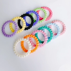 Set di dodici anelli da dentizione colorati in silicone con texture a sfere per neonati