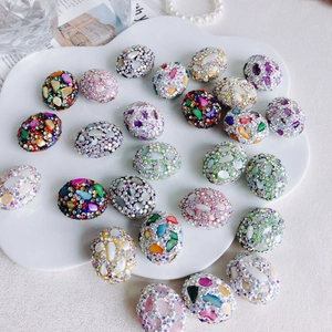 Close-up of colorful floral rhinestone beads with mosaic shell patterns for DIY jewelry