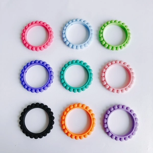 Dettaglio di nove anelli in silicone colorati con trama a rilievo per accessori gioielli DIY
