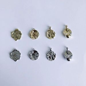 Close-up of vintage relief coin charms in gold and silver finishes for DIY jewelry making