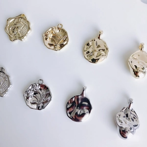 Assorted gold and silver vintage coin pendants with embossed floral and portrait designs