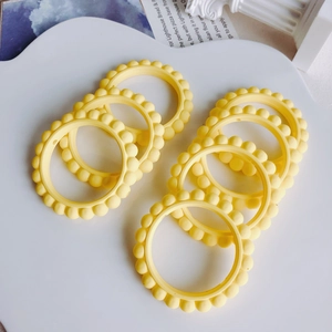 Dettaglio di sette anelli di perline in acrilico giallo chiaro per gioielli fai-da-te