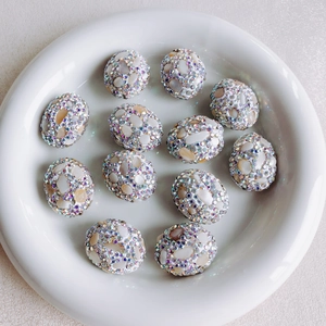 Macro view of floral crystal beads on ceramic tray for DIY jewelry making
