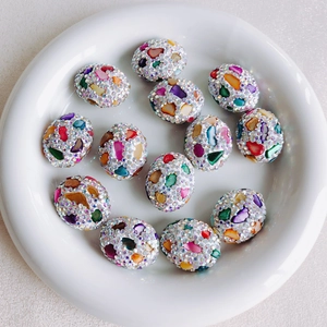 Macro view of assorted mosaic floral beads with colorful shell fragments and crystals