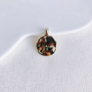 Detailed view of round vintage coin pendant with gold finish and brown marble texture