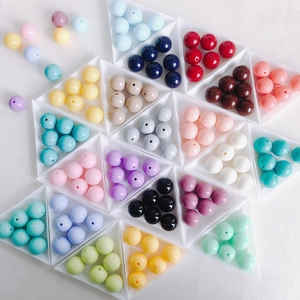 Colorful macaron acrylic round beads displayed in triangular trays for DIY jewelry making