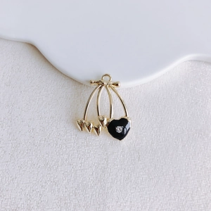 Detailed close-up of heart cherry pendant with gold alloy and black enamel finish