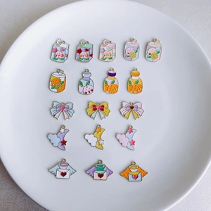 Detailed close-up of pastel enamel alloy charms for DIY jewelry making in a white plate