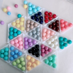 Flat lay of assorted colorful acrylic beads organized in triangular trays for DIY crafts