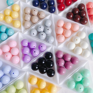 Flat lay of colorful acrylic beads in triangle trays for DIY jewelry making and crafts