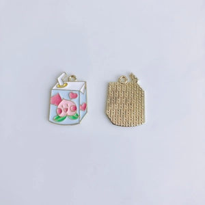 Detail of alloy milk carton pendants showing blue peach pattern and gold grid back