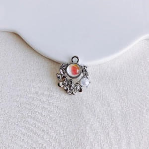 Macro detail of silver floral pendant with coral stone and pearl for DIY jewelry making