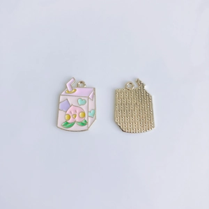 Detailed view of pink peach milk carton alloy charm with golden textured reverse side