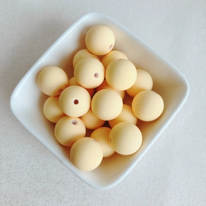 Gros plan de perles en caoutchouc jaune mat avec trous pour la création de bijoux DIY