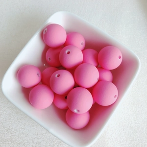 Gros plan de perles rondes rose mat macaron dans un bol blanc pour bijoux DIY