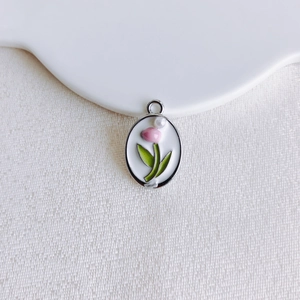 Macro shot of silver oval tulip pendant with pink enamel and pearl for DIY jewelry
