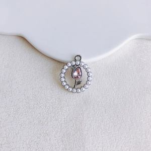 Detail of silver floral pendant with pink teardrop crystal and white pearl halo