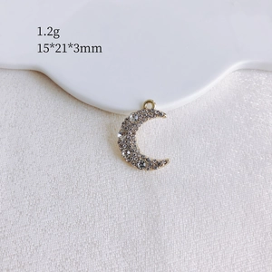 Macro view of moon shaped pendant with clear rhinestones and 15x21x3mm size details