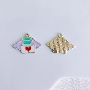 Detailed macro view of heart envelope and angel wing charms with golden textured back