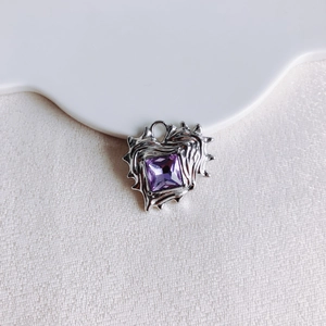 Detailed macro view of purple heart zircon pendant with irregular silver liquid metal frame