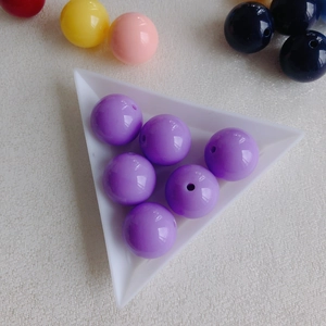 Detail of purple acrylic round beads for DIY jewelry making with smooth glossy finish