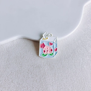 Detail of a milk carton enamel pendant with a cute peach pattern for jewelry making