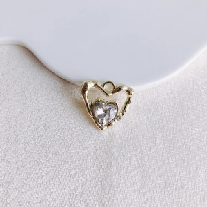 Vue macro d'un pendentif cœur en alliage avec zircon étincelant sur tissu blanc texturé