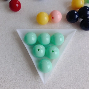 Macro shot of colorful round acrylic beads in a triangle tray for DIY jewelry making