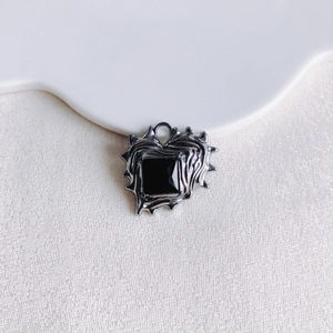 Macro view of gothic heart pendant with black faceted gemstone and molten metal texture