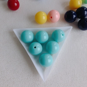 Macro shot of colorful acrylic round beads for DIY jewelry making in a white tray
