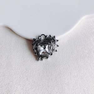 Close-up of heart pendant with irregular lava texture and square-cut zircon stone