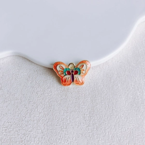 Détail macro du pendentif papillon en émail multicolore pour création de bijoux DIY