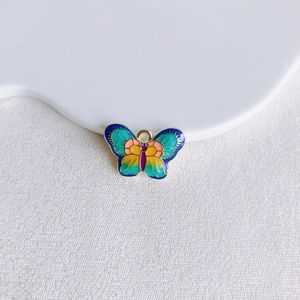 Détail d'un pendentif papillon en alliage coloré avec finition en émail dégradé vif