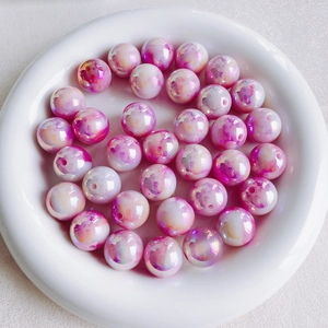 Macro-opname van 16mm roze en paarse acryl kralen met wolkeffect in een witte schaal