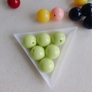 Close-up of light green large hole acrylic beads in a white tray for DIY jewelry