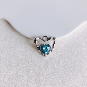 Détail macro d'un pendentif cœur en cristal bleu scintillant avec cadre en métal argenté