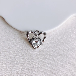 Détail du pendentif cœur en cristal avec cadre argenté au style métal liquide moderne