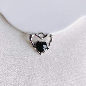 Macro détaillée d'un pendentif cœur noir facetté avec cadre en alliage argenté pour bijoux