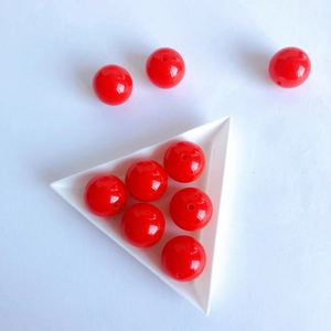Macro shot of glossy red acrylic beads with center holes for DIY jewelry making